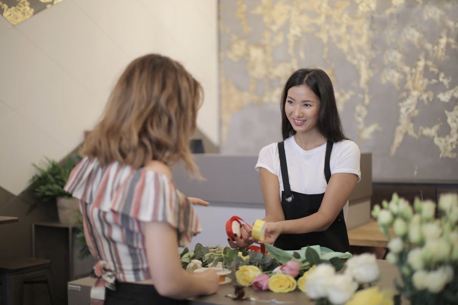 A professional florist from southcroydonflorist.co.uk is seen delivering a floral gift in a well-lit, contemporary shop setting. She is smiling and holding a flower arrangement wrapped in clear cellop